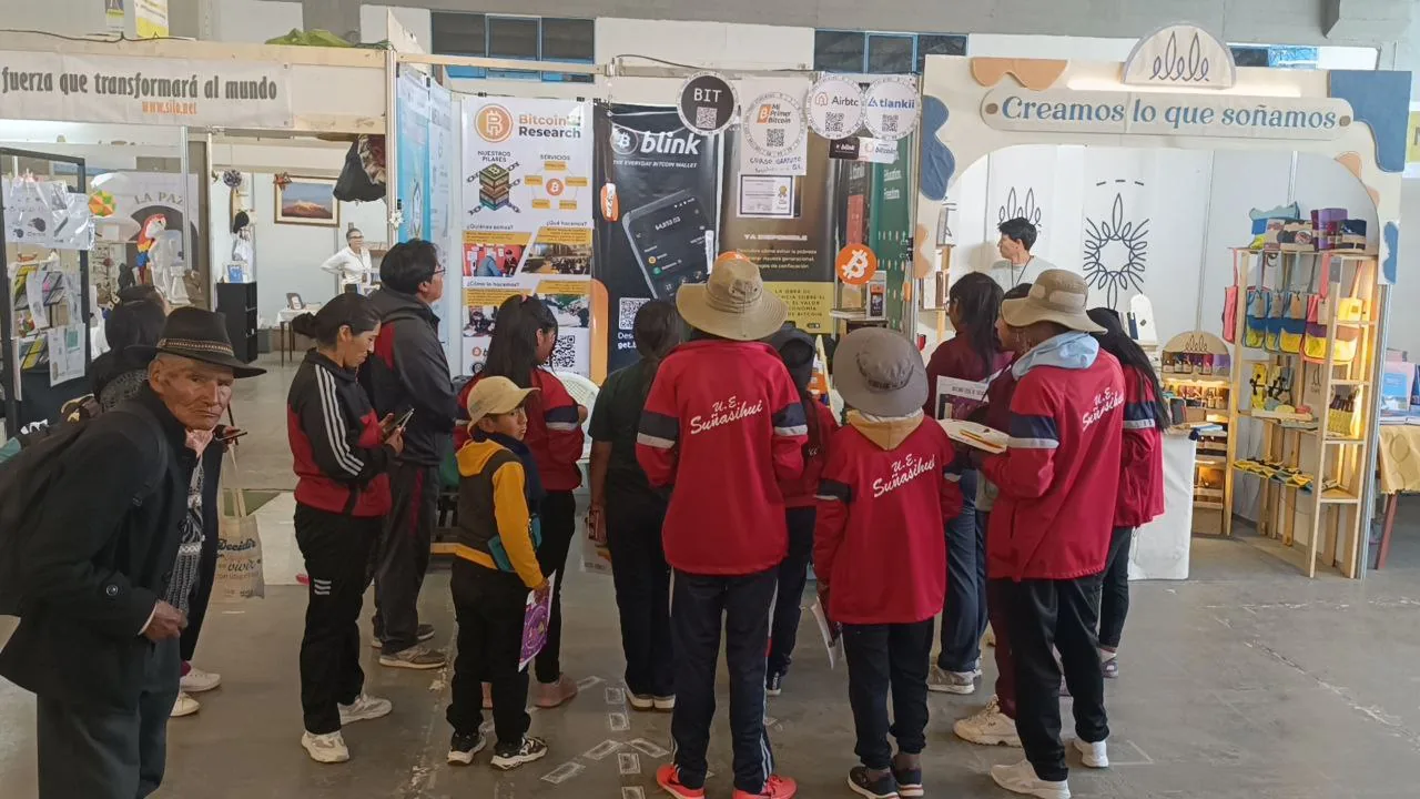 Estudiantes aprendiendo Bitcoin en feria